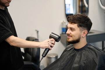 Professional uses dryer to style and shape client hair
