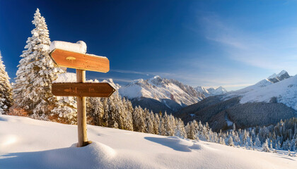 A snow-covered wooden directional sign stands in deep powder snow against a breathtaking backdrop of snow-capped mountain peaks and frost