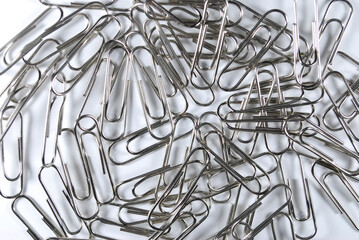 metal paper clips scattered on a white background