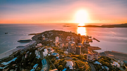 Aerial view of Downtown Port Moresby and Paga Hill from Touaguba Hill with a golden sunset horizon beyond Fisherman Island