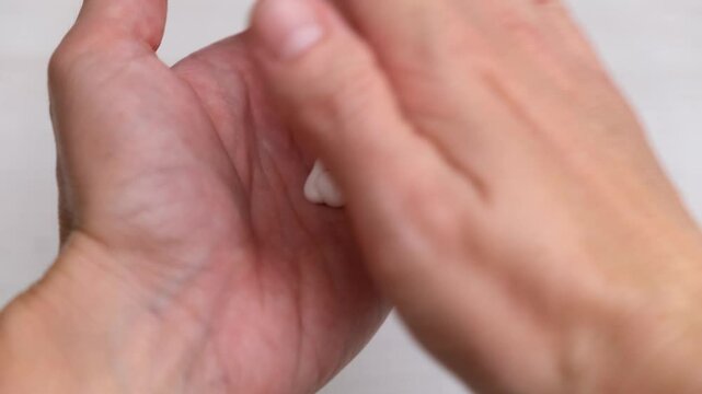Woman applying nourishing cream on hands close up