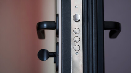 Door lock on an open armored entrance door. Latch and metal bolt on the door lock. Rubber tubular...