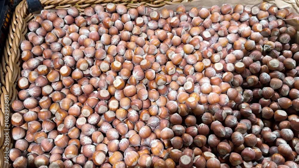 Poster wicker baskets overflowing with hazelnuts in their shells create a vibrant display at a market. the 
