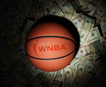 Raleigh, NC - USA - 11-07-2024: Basketball with WNBA text and logo surrounded by money