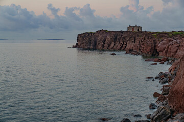 Beautiful view of the seaside mountain rocky shore, illuminated by the setting sun