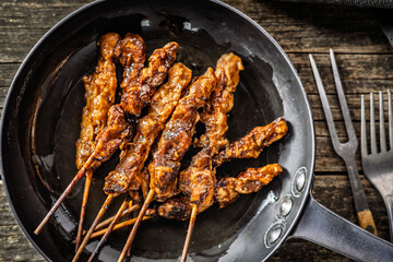 Japanese chicken yakitori on pan on wooden table. Top view.