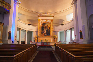 The neoclassical altar area of Helsinki Cathedral features an ornate altarpiece, classical columns,...
