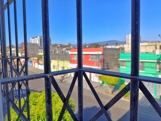 Urban Street View of Guatemala City through Metal Fence