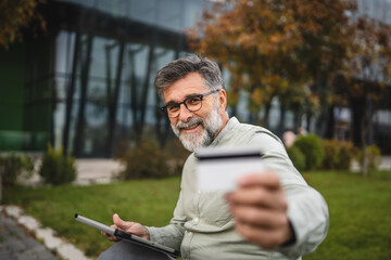 Fototapeta premium Senior man buy online on digital tablet with credit card outdoor