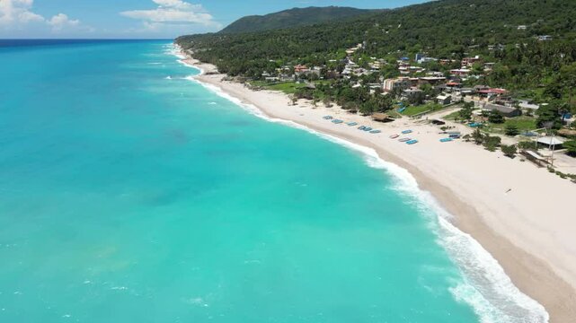 view of Kalki Beach with boats on the sand in front of green mountain in Sabana Westpunt, Curacao
