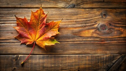 Obraz premium A Single Maple Leaf Resting on Rustic Wooden Planks, A Symbol of Autumn's Tranquil Beauty