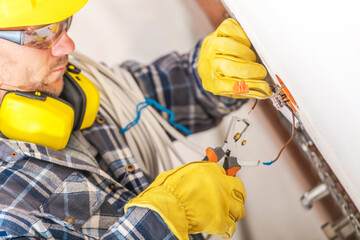 Electrician Working on Wiring Installation in a Residential Setting During Daylight Hours