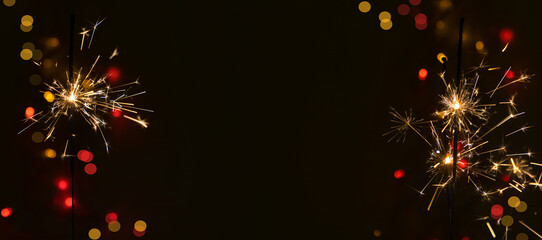 Beautiful glowing sparklers on a dark background. Colorful sparklers sparkling on a black bokeh...