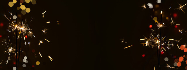 Beautiful glowing sparklers on a dark background. Colorful sparklers sparkling on a black bokeh...