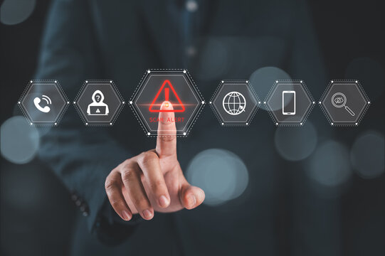 Cybersecurity scam alert warning concept. A hand interacts with a virtual interface displaying icons for scam alert, fraud detection, and online security, cybersecurity awareness and fraud prevention.