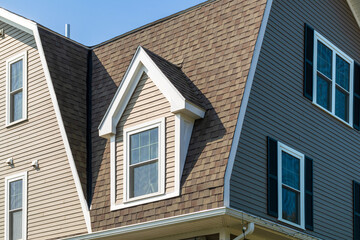 Dormer window and steep shingled roof on a charming family home in Brighton, Massachusetts, USA
