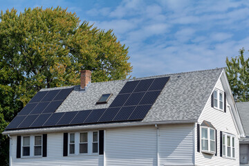 Solar panels installed on a gray-shingled roof of a family house in Brighton, Massachusetts, USA
