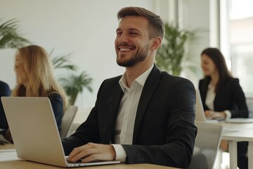 Obraz premium Young Professional Smiles Confidently While Working on a Laptop in a Modern Office During a Sunny Afternoon