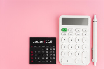 Top view of January 2025 calendar and white calculator with pen on pink background.