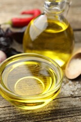 Cooking oil in bowl on wooden table, closeup