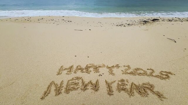 Happy new year 2025 ,word beach written on the sand