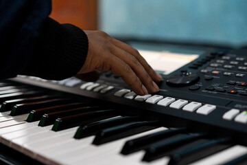 Fototapeta premium close up portrait of male hands playing a keyboard instrument.