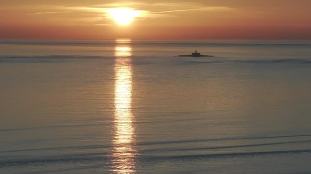 Aerial drone shot of the Forte do Bugio lighthouse, Tagus river, Atlantic Ocean and horizon at sunset from Lisbon, Portugal, Europe. Shot in ProRes 422 HQ