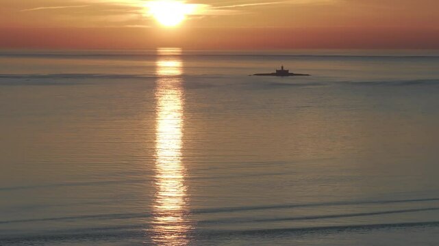 Aerial drone shot of the Forte do Bugio lighthouse, Tagus river, Atlantic Ocean and horizon at sunset from Lisbon, Portugal, Europe. Shot in ProRes 422 HQ