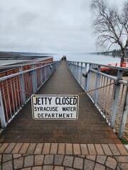 pier by lake with closed sign