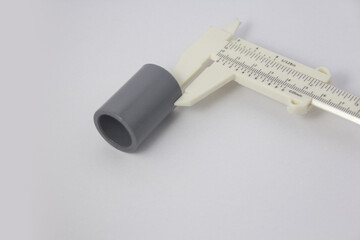Measuring wall thickness with a vernier caliper. Wall thickness of a PVC socket.