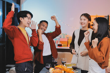 Group of young Asian man and women as friends having fun at a New Year's celebration, holding gift...