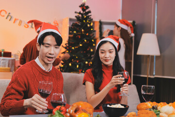 Group of young Asian man and women as friends having fun at a New Year's celebration, holding gift...