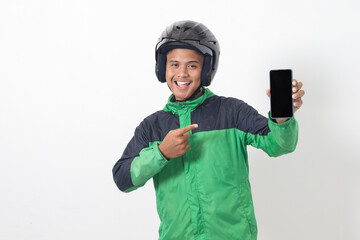 Portrait of Asian online taxi driver wearing green jacket and helmet showing and presenting blank screen mobile phone. Isolated image on white background