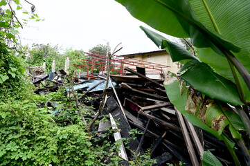 Obraz premium BANGKOK, THAILAND - November 15, 2024: Debris from a house after a fire caused by an electrical short circuit with natural background at Thailand.