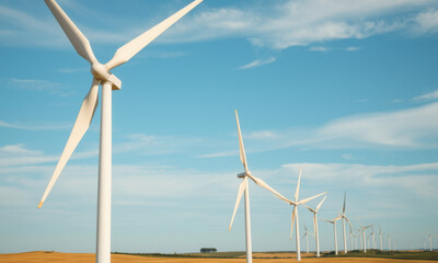 Fototapeta premium scenic view of wind farm with multiple turbines against clear blue sky, showcasing renewable energy and sustainable practices