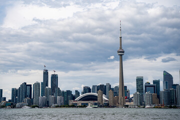 Fototapeta premium View of the CN Tower and Roger Centre in Downtown Toronto from the Toronto Islands cloudy weather. Toronto, Canada - August 22, 2024.