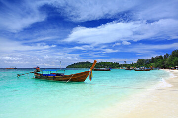 Obraz premium Scenic view white sand beach and crystal Andaman Sea against blue sky at Koh Lipe in Satun Province, Thailand 