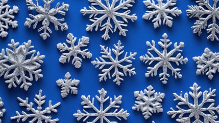 Fototapeta premium Silver glitter snowflakes on blue background