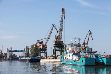Portal cranes are on the river coast