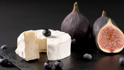 fresh cheese and figs on a black table