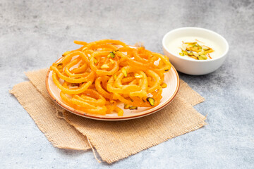 Golden, spiraled jalebi served with creamy, sweet rabdi; a luscious Indian dessert pairing of...