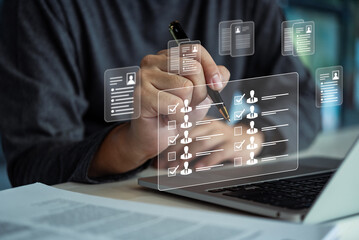 Hand reviewing and checking profiles using a holographic interface on a laptop. Highlights...