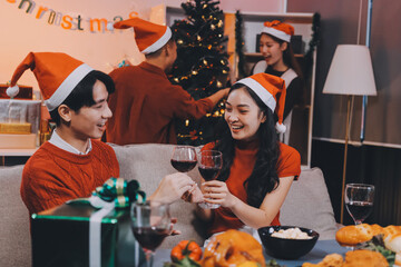 Group of young Asian man and women as friends having fun at a New Year's celebration, holding gift...
