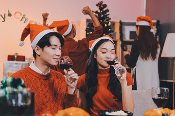 Group of young Asian man and women as friends having fun at a New Year's celebration, holding gift...