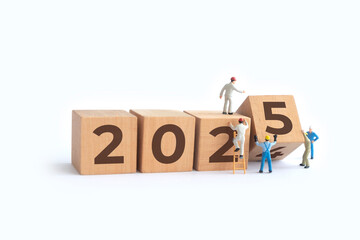 Transitioning from 2024 to 2025 with wooden blocks and miniature people. new year 2025 concept.