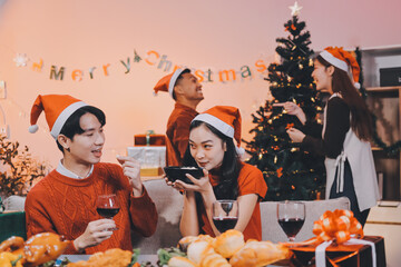 Group of young Asian man and women as friends having fun at a New Year's celebration, holding gift...