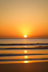 Obraz premium Sunset, Sky clouds over sea in the Evening with Orange, Yellow Gold sunlight in Golden hour and Dramatic fluffy, Horizon sea Summer sky landscape, Dusk sky background