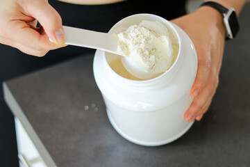 Close up of woman preparing a protein shake in the kitchen. Diet meal replacement for weight loss 