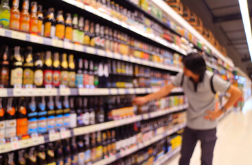 Abstract blurred of a man shopping liquor in a grocery store