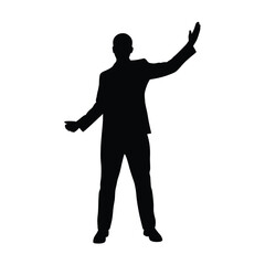 A man in a suit is standing in front of a white background. He is wearing black shoes and a black jacket